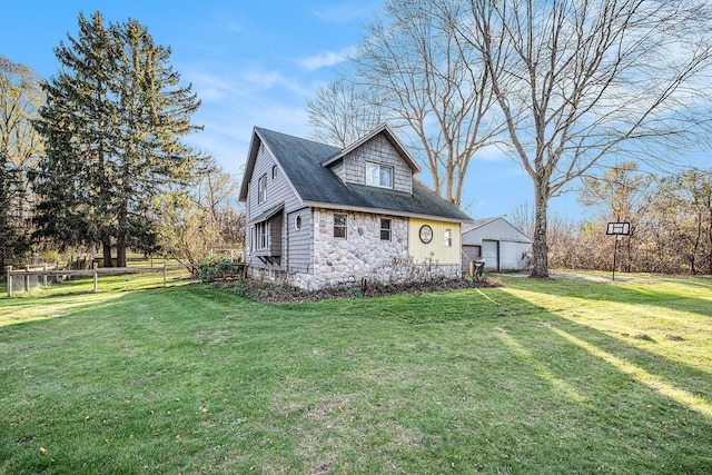 view of side of home featuring a lawn, an outbuilding, and a garage