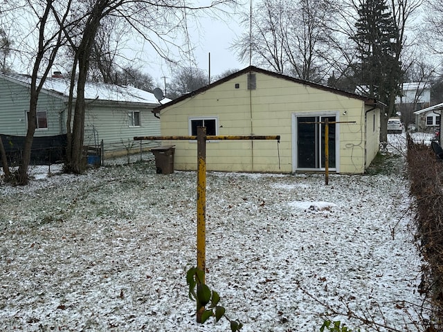 view of snow covered back of property