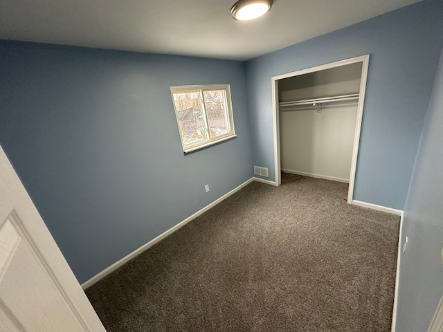 unfurnished bedroom featuring carpet flooring and a closet