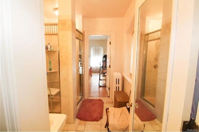 hall featuring radiator heating unit and light tile patterned floors