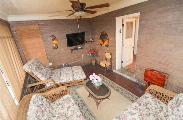 living room featuring ceiling fan and brick wall