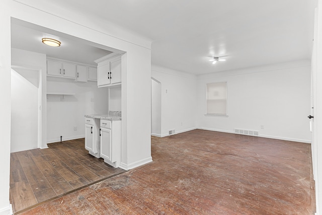 kitchen with white cabinets, dark hardwood / wood-style floors, and light stone countertops