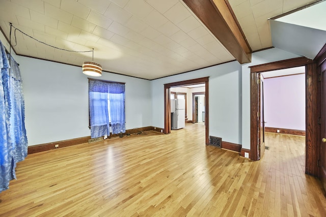 unfurnished room with beamed ceiling and light hardwood / wood-style flooring