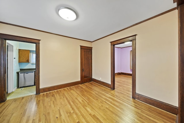 spare room featuring crown molding and light wood-type flooring