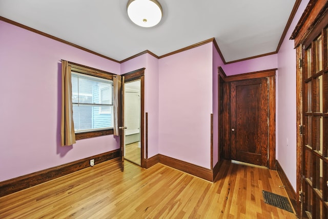 interior space featuring crown molding and light wood-type flooring