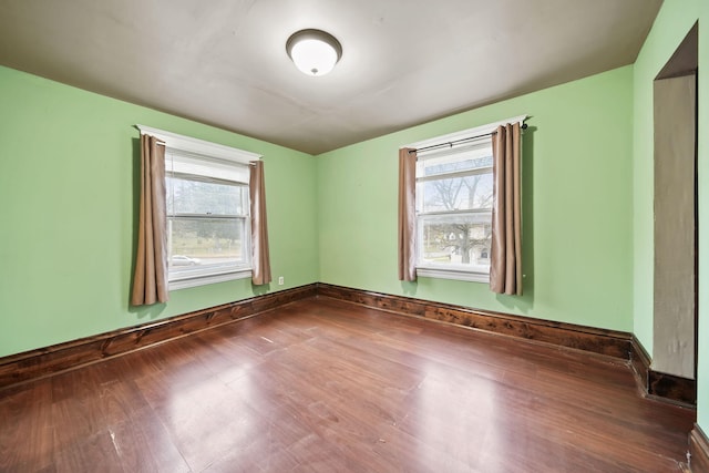 empty room featuring plenty of natural light and wood-type flooring