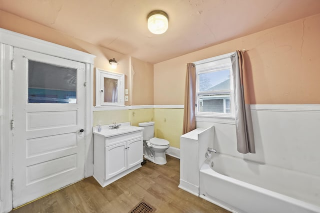 bathroom featuring a tub, toilet, vanity, and hardwood / wood-style flooring