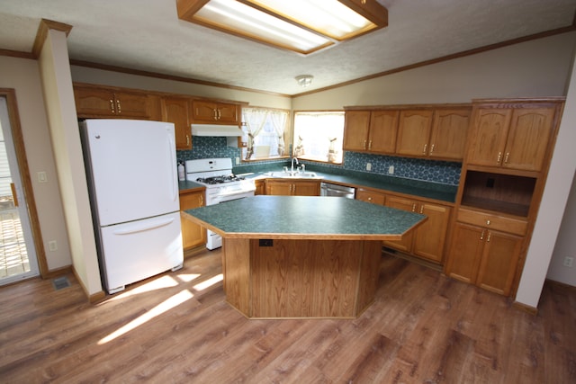 kitchen featuring lofted ceiling, white appliances, sink, a kitchen island, and dark hardwood / wood-style flooring