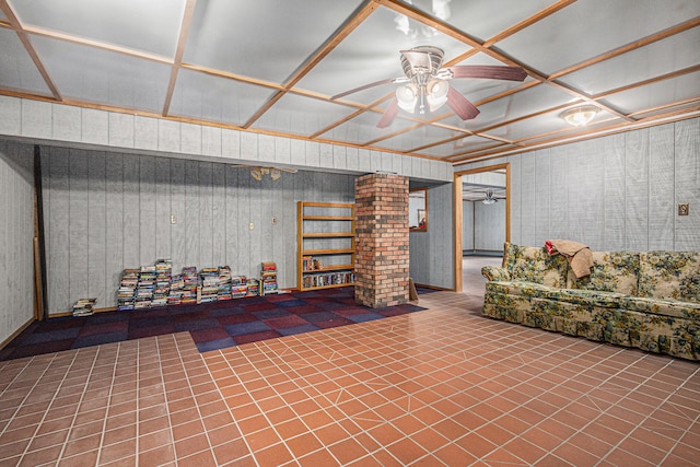 basement with ceiling fan and wooden walls