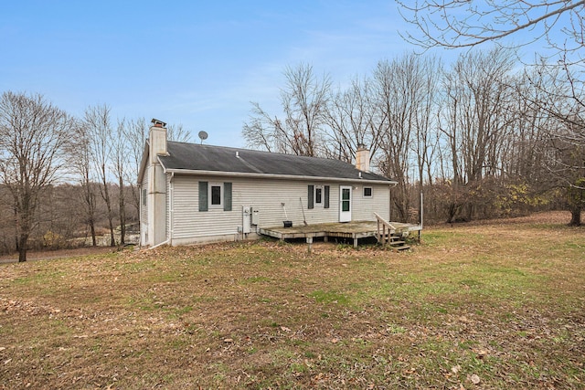 back of property featuring a yard and a wooden deck