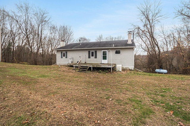 rear view of property featuring a yard and a wooden deck