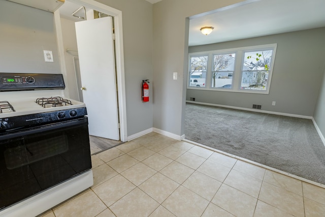 kitchen with white range with gas cooktop and light carpet