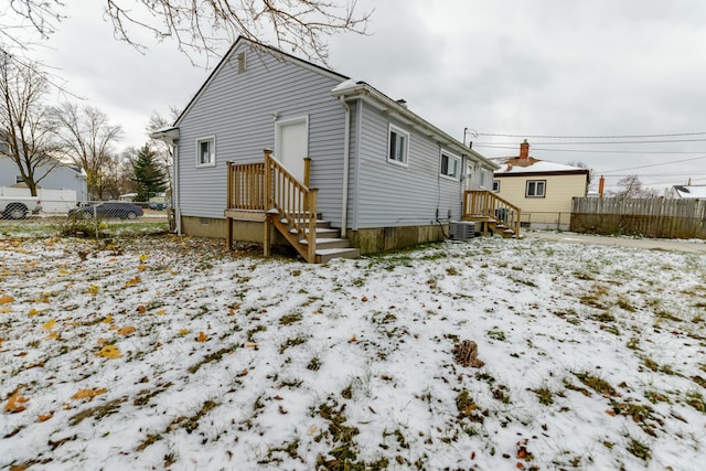 snow covered house with central AC unit