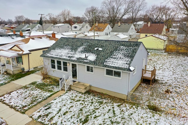 view of snow covered back of property