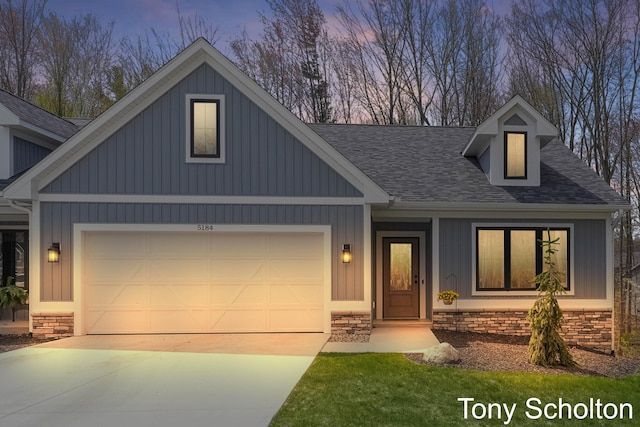craftsman-style house with a garage, board and batten siding, roof with shingles, and concrete driveway