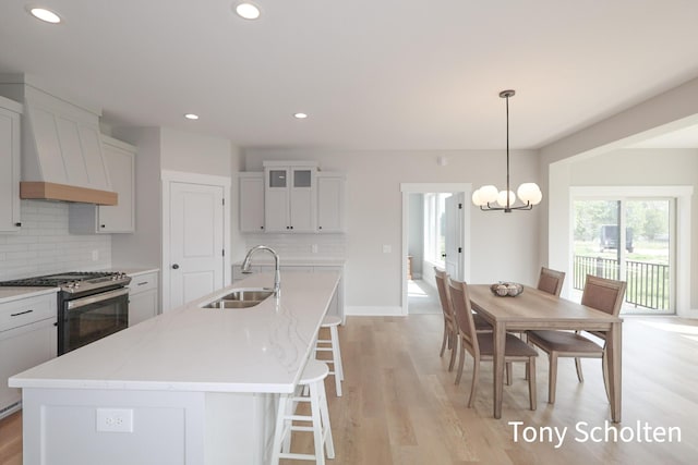 5184 Blendon Meadow Cir Unit 47, Hudsonville, MI 49426 - kitchen with a sink, stainless steel gas range, backsplash, custom range hood, and a chandelier