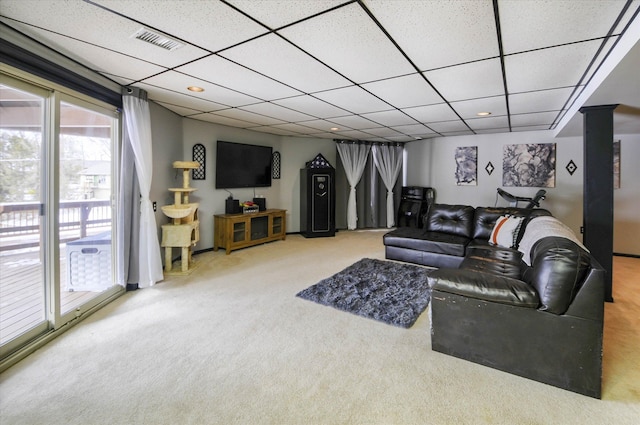 living room featuring a drop ceiling, carpet floors, and ornate columns