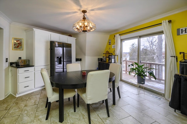 dining area featuring crown molding and a notable chandelier