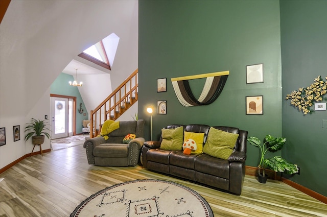 living room with a high ceiling, a notable chandelier, and hardwood / wood-style flooring