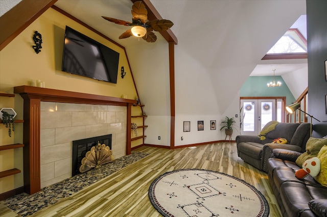 living room with light hardwood / wood-style floors, a wealth of natural light, lofted ceiling, and a tiled fireplace