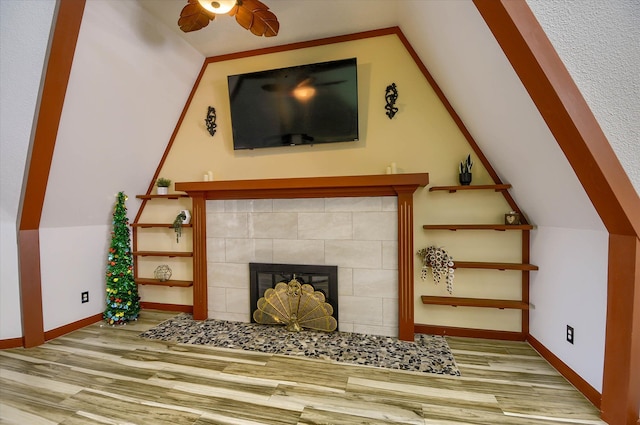 unfurnished living room featuring light hardwood / wood-style floors, lofted ceiling, and a tile fireplace