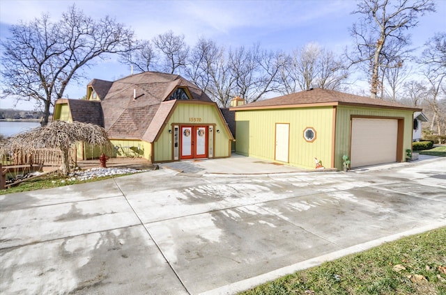 view of front of property featuring an outbuilding, a water view, and a garage