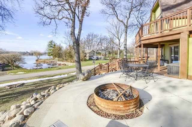 view of patio / terrace with a deck with water view and an outdoor fire pit