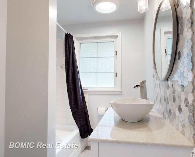 bathroom featuring shower / bath combo with shower curtain and sink