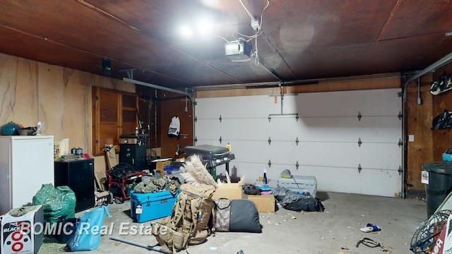 garage featuring a garage door opener and wooden walls