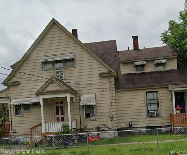 view of front facade with cooling unit and a front lawn