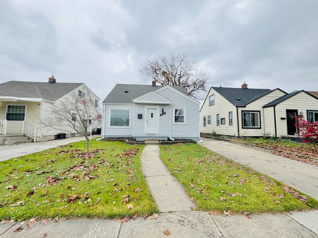 bungalow-style home with a front yard