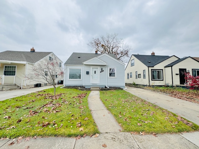 bungalow-style home with a front yard