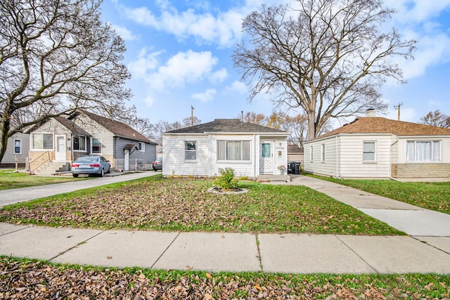 bungalow-style home featuring a front lawn