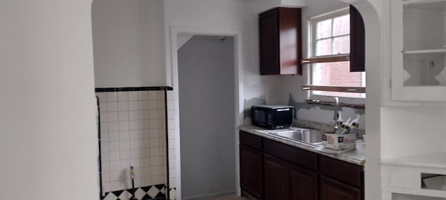 kitchen featuring dark brown cabinetry and sink