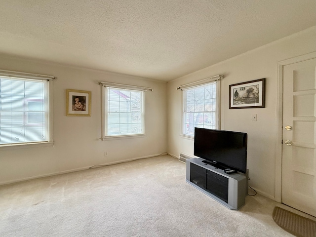 unfurnished living room with light carpet and a textured ceiling