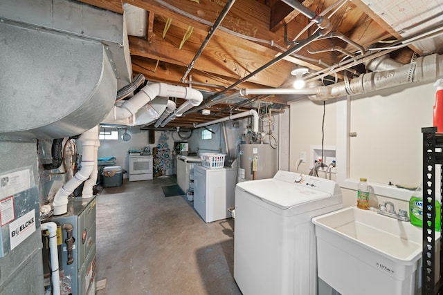 basement with water heater, washing machine and dryer, and sink