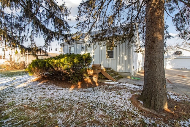 yard covered in snow with an outdoor structure and a garage