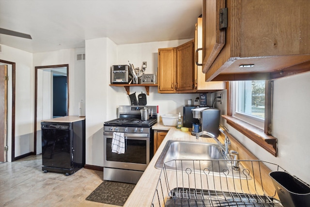 kitchen featuring sink, black fridge, and stainless steel gas range