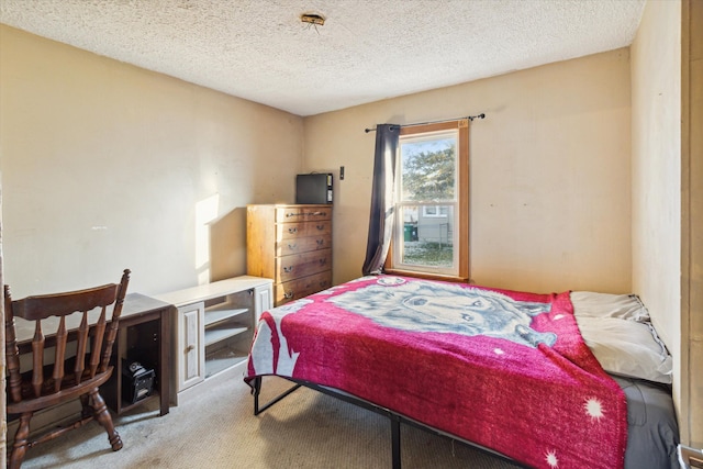 bedroom featuring carpet flooring and a textured ceiling