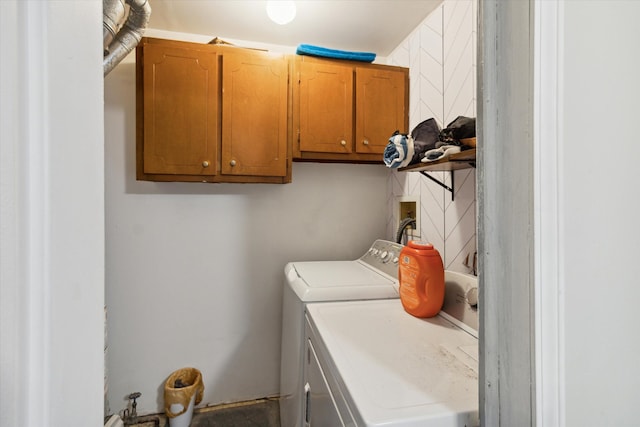 laundry area featuring separate washer and dryer and cabinets