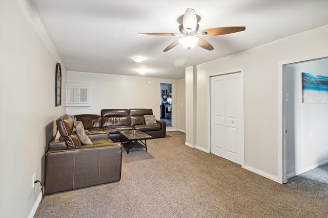 carpeted living room with ceiling fan