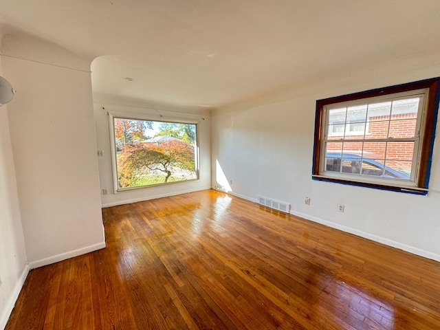 spare room with hardwood / wood-style floors and a healthy amount of sunlight