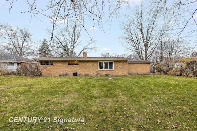 rear view of property featuring a lawn