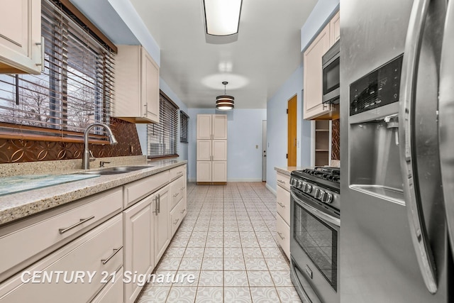 kitchen with light stone countertops, sink, stainless steel appliances, decorative light fixtures, and light tile patterned floors