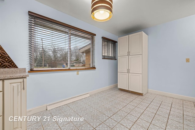 tiled spare room with a baseboard radiator