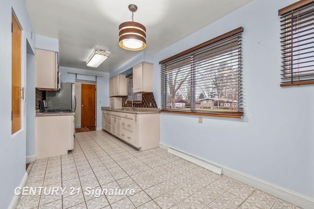 kitchen with stainless steel fridge, light tile patterned floors, baseboard heating, and sink