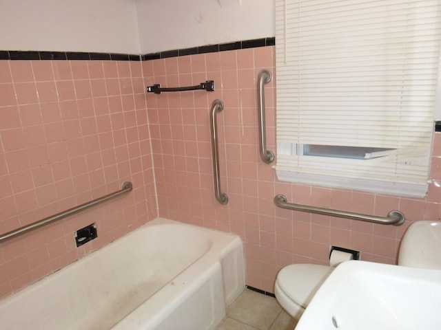 bathroom with tile patterned flooring, tile walls, and toilet