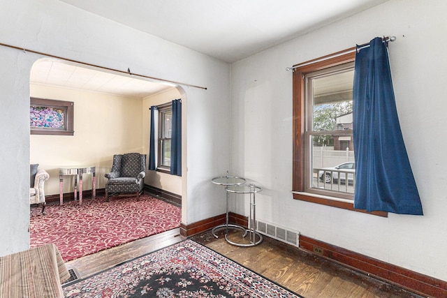 sitting room with hardwood / wood-style floors, baseboards, and arched walkways