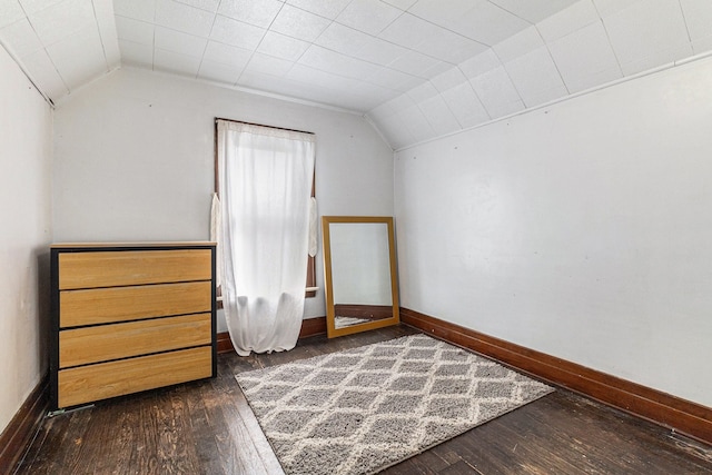 additional living space featuring lofted ceiling, baseboards, and dark wood-style floors