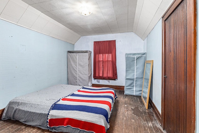 bedroom with wood-type flooring, vaulted ceiling, and baseboards